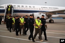 ภาพที่สำนักข่าวซินหัวเผยแพร่ออกมาแสดงให้เห็นพลเมืองจีนกลุ่มหนึ่งที่ต้องสงสัยว่าเกี่ยวข้องกับอาชญากรรมฉ้อโกงและแก๊งคอลเซนเตอร์ ขณะถูกตำรวจจีนในเมืองนานจิงนำตัวไปลงจากเครื่องบิน หลังถูกส่งตัวกลับมาจากไทย เมื่อ 20 ก.พ. 2568