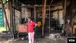 Fred Yokossa, a bakery employee, stands next to a generator in Bangui, Central African Republic, Dec. 1, 2015. (C. Stein/VOA)