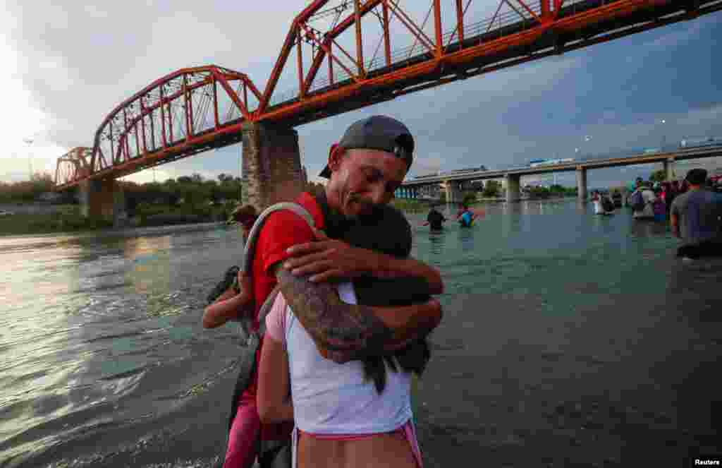 Asylum seekers wait on the banks of the Rio Bravo river after crossing during their journey through Mexico to Eagle Pass, Texas, in Piedras Negras, Mexico, Sept. 26, 2023.