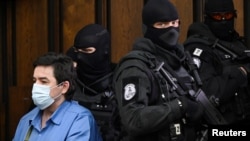 Slovak businessman Marian Kocner is escorted by security officers into the Slovak Supreme Court as he appears on charges of ordering and carrying out the murders of journalist Jan Kuciak and his fiancee Martina Kusnirova, in Bratislava, June 15, 2021.
