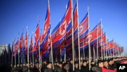 FILE - North Koreans parade with the North Korean flag in Kim Il Sung Square in Pyongyang to show their loyalty to the Workers' Party, Feb. 25, 2016. The resolution, drafted by the United States and introduced last Thursday, calls for a total arms embargo on Pyongyang.