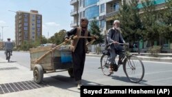Sal Mohammad, 25, an Afghan man who gathers pieces of iron from the street to sell for scrap, pushes his handcart in Kabul, Afghanistan, Tuesday, Aug. 31, 2021. (AP Photo/Sayed Ziarmal Hashemi)