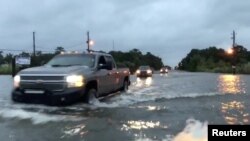Cars drive through a flooded road in Mobile, Alabama, U.S., October 8, 2017, in this still image taken from a video obtained from social media. Michael Schubert/social media/via Reuters. 