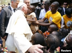 Pope Francis kisses a child as he visits the refugee camp of Saint Sauveur in the capital Bangui, Central African Republic, Nov. 29, 2015.