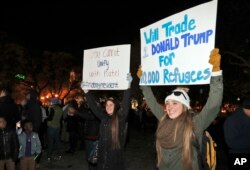 Protesters hold signs during an election protest in Lafayette Square Park in front of the White House in Washington, Nov. 12, 2016.
