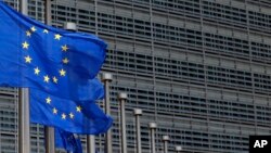 FILE - European Union flags set of half staff outside the European Commission headquarters in Brussels, Belgium.