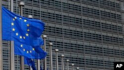 FILE - European Union flags set of half staff outside the European Commission headquarters in Brussels, Belgium.