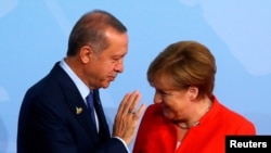 Le président Recep Tayyip Erdogan discute avec la chancelière allemande Angela Merkel à son arrivée au sommet de G20 à Hamburg. 07 Juillet 2017