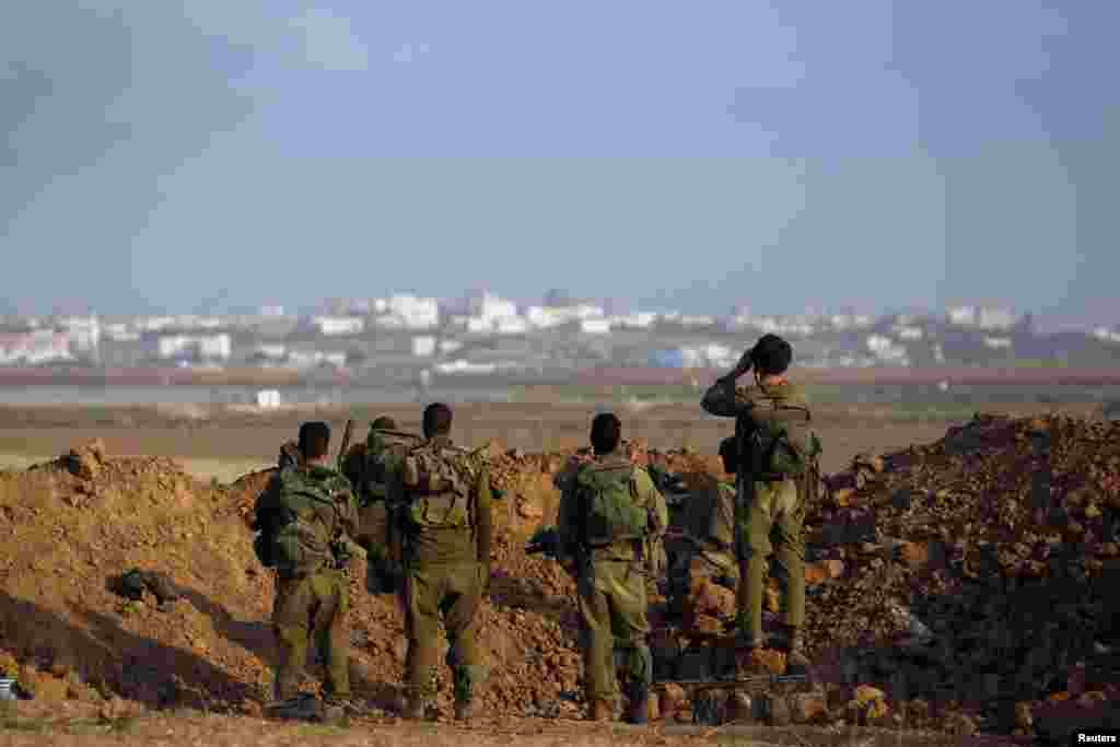 Israeli soldiers look towards Gaza from Israel.
