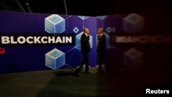 FILE - A participant talks on his phone at the Delta Summit, a blockchain and digital innovation event, in Ta'Qali, Malta, Oct. 3, 2019.