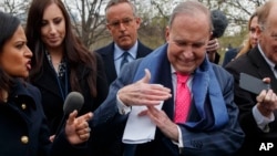 白宫首席经济顾问库德洛在白宫外对记者做“暂停”手势