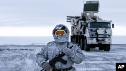 In this photo taken on April 3, 2019, a Russian solder stands guard near a Pansyr-S1 air defense system on the Kotelny Island, part of the New Siberian Islands archipelago located between the Laptev Sea and the East Siberian Sea, Russia. 