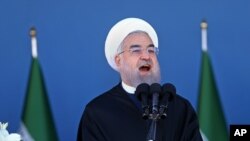 Presiden Iran Hassan Rouhani berpidato dalam pawai militer yang menandai perayaan Hari Angkatan Darat Nasional di Teheran (17/4). (AP/Ebrahim Noroozi)