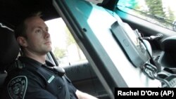 In this Wednesday, May 8, 2019, photo, Anchorage Police Officer T. Scott Masten works a shift in Anchorage, Alaska, equipped with a wireless hotspot device on his patrol car laptop. (AP Photo/Rachel D'Oro)