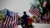 Момче носи американски знамиња низ селото Барнстејбл, Масачусетс, за време на годишната парада на четврти јули на која се прославува Денот на независноста на САД, 4 јули 2024 година.