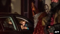 Members of circus company Cirk La Putyka, dressed as Saint Nicholases, entertain people during their drive-through performance, Dec. 5, 2020 in Prague.