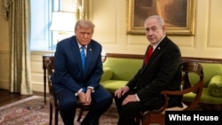 资料照片：2025年7月7日，美国总统特朗普和以色列总理内塔尼亚胡在白宫晚宴前交谈。