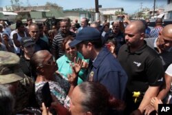 Puerto Rico's Governor Ricardo Rossello (center) talks to a woman during a distribution of relief items, after the area was hit by Hurricane Maria in San Juan, Puerto Rico Sept. 24, 2017.