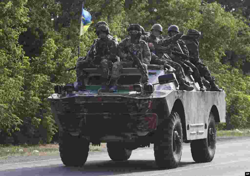 Ukrainian soldiers ride atop an APC near the village of Sakhanka, in eastern Ukraine, Aug. 27, 2014.