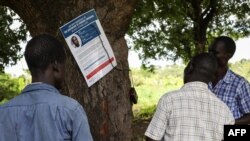 Residents of Lukodi village, where dozens were killed in 2004 by the Lord's Resistance Army, react as they listen to the International Criminal Court's sentence of Dominic Ongwen, on radio in Lukodi, Uganda, May 6, 2021. 