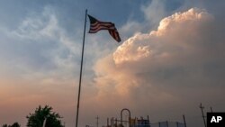Plumes of smoke from the Bootleg Fire rise over a playground, July 12, 2021, near Bly, Ore.