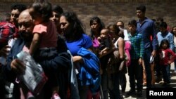 Keluarga migran yang mencari suaka dilepaskan dari tahanan federal di sebuah depot bus di McAllen, Texas, AS, 31 Juli 2019. (Foto: Reuters/Loren Elliott)