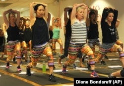 Women wear leggings while practicing yoga.