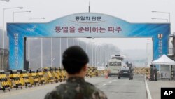South Korean soldiers stand as vehicles carrying a South Korean delegation pass the Unification Bridge, which leads to the Panmunjom in the Demilitarized Zone in Paju, South Korea, Thursday, March 29, 2018. (AP Photo/Lee Jin-man)