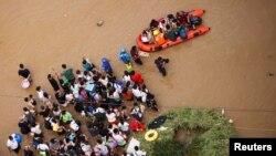 Warga yang terdampak banjir di Zhengzhou, provinsi Henan, China, menunggu untuk dievakuasi, 22 Juli 2021. (REUTERS/Aly Song)
