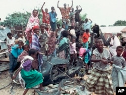 FILE - In this Oct. 19, 1993 photo, a group of young Somalis chant anti-American slogans while sitting atop the burned out hulk of a U.S. Black Hawk helicopter, shot down during a firefight with Somali guerrillas, in Mogadishu, Somalia.