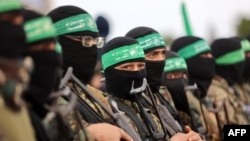 Para kombatan Hamas berkumpul di lokasi penyerahan dua sandera Israel di Rafah di Jalur Gaza selatan, sebagai bagian dari pembebasan sandera-tahanan ketujuh pada 22 Februari 2025. (Foto: Omar Al-Qattaa/AFP)