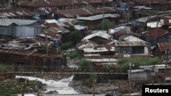 FILE - People walk along a bridge before a curfew which was ordered by the Kenya's President Uhuru Kenyatta to contain the spread of the coronavirus disease (COVID-19), within Kibera slums in Nairobi, Kenya, March 27, 2020. 