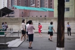 지난 2019년 6월 북한 평양의 지하철역 주변에서 휴대전화를 사용하는 시민들.