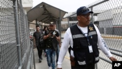 
Seorang penjaga keamanan mengarahkan sekelompok pencari suaka dari keluar dari kantor imigrasi Meksiko setelah mereka dikembalikan oleh otoritas AS, di Ciudad Juarez, Meksiko, 17 Juli 2019.
