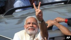 India's main opposition Bharatiya Janata Party’s PM candidate Narendra Modi displays the victory symbol after casting his vote in Ahmadabad, April 30, 2014.
