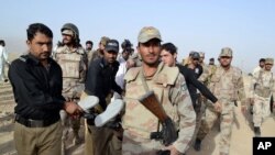 Pasukan paramiliter Pakistan membawa mayat seorang militan yang tewas dalam serangan di Quetta, Pakistan, Jumat, 15 Agustus 2014.