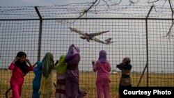 Anak-anak melihat pesawat terbang sambil menutup telinga di bandar udara Adi Soemarmo, Solo. (Foto: Dok)