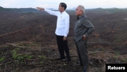FILE - Indonesian President Joko Widodo gestures as Governor of East Kalimantan Isran Noor stands during their visit to an area, planned to be the location of Indonesia's new capital in East Kalimantan, Indonesia December 17, 2019. (Antara Foto/Akbar Nugroho Gumay/via REUTERS) 