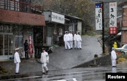 Police officers stand guard before Russia's President Vladimir Putin leaves a hot spring resort, the venue of the summit meeting between Japanese Prime Minister Shinzo Abe and Putin, Dec. 15, 2016, during snow falling in Nagato, Yamaguchi prefecture, Japan.