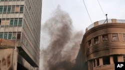 Protesters set fires and throw stones during clashes with security forces in Baghdad, Iraq, Nov. 28, 2019. 