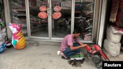 A man fills a generator with petrol outside his shop during a power outage in Rawalpindi, Pakistan, June 3, 2013. 