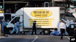 Petrugas forensik memindahkan mobil van di Finsbury Park, utata London, di mana sebuah kendaraan menabrak pejalan kaki di London utara, 19 Juni 2017. (AP Photo/Frank Augstein).