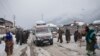 An ambulance ferries patients to a hospital through a snow-covered road in Kangan, north of Srinagar, India-controlled Kashmir, Jan. 14, 2020.