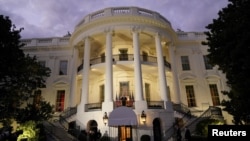 Presiden AS Donald Trump berdiri di balkon Truman Gedung Putih, Washington, D.C., setelah melepas masker yang dikenakannya sepanjang perjalanan dari RS Walter Reed pasca perawatan positif Covid-19, 5 Oktober 2020.