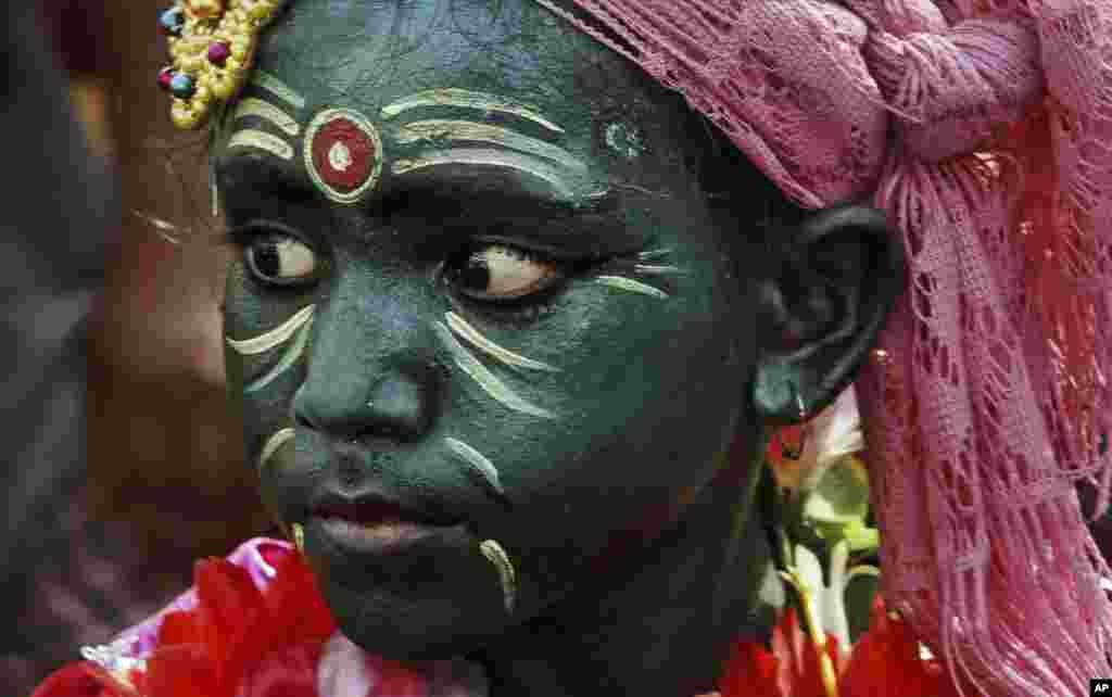 Seorang anak laki-laki India dengan wajah yang dicat, mengikuti prosesi keagamaan festival Chandan Yatra di kota Puri, India timur.