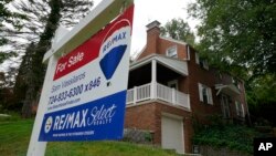 FILE - A 'for sale' sign is displayed outside a home in Mount Lebanon, Pa., Sept. 21, 2021.