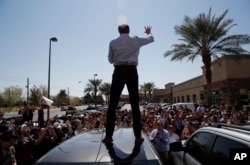 Democratic presidential candidate and former Texas congressman Beto O'Rourke speaks from the roof of his car to an overflow crowd at a campaign stop at a coffee shop Sunday, March 24, 2019, in Las Vegas.