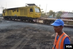 A worker looks on as Cambodia's sole trainline is loaded with cargo destined for the counrty's largest seaport in Sihanoukville. (D. de Carteret for VOA)