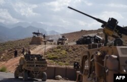 FILE - U.S. Army and Afghan commando forces are seen at a checkpoint during a patrol against Islamic State militants, at Deh Bala district in the eastern Afghan province of Nangarhar, July 7, 2018.