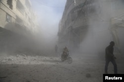 FILE - People are seen during shelling in the town of Hamoria, eastern Ghouta, in Damascus, Syria, Dec. 3, 2017.